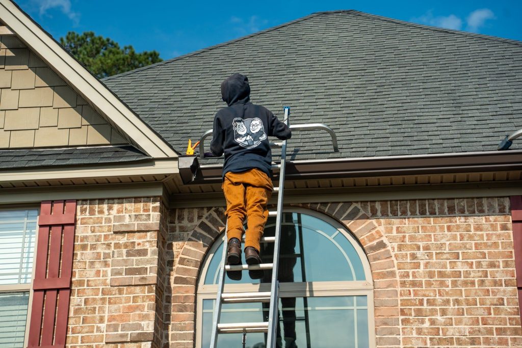 Installer on a ladder at a brick home