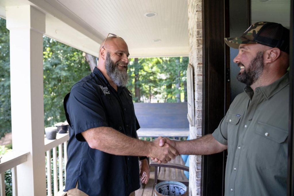 Solutionist shaking hands with a homeowner on the front porch