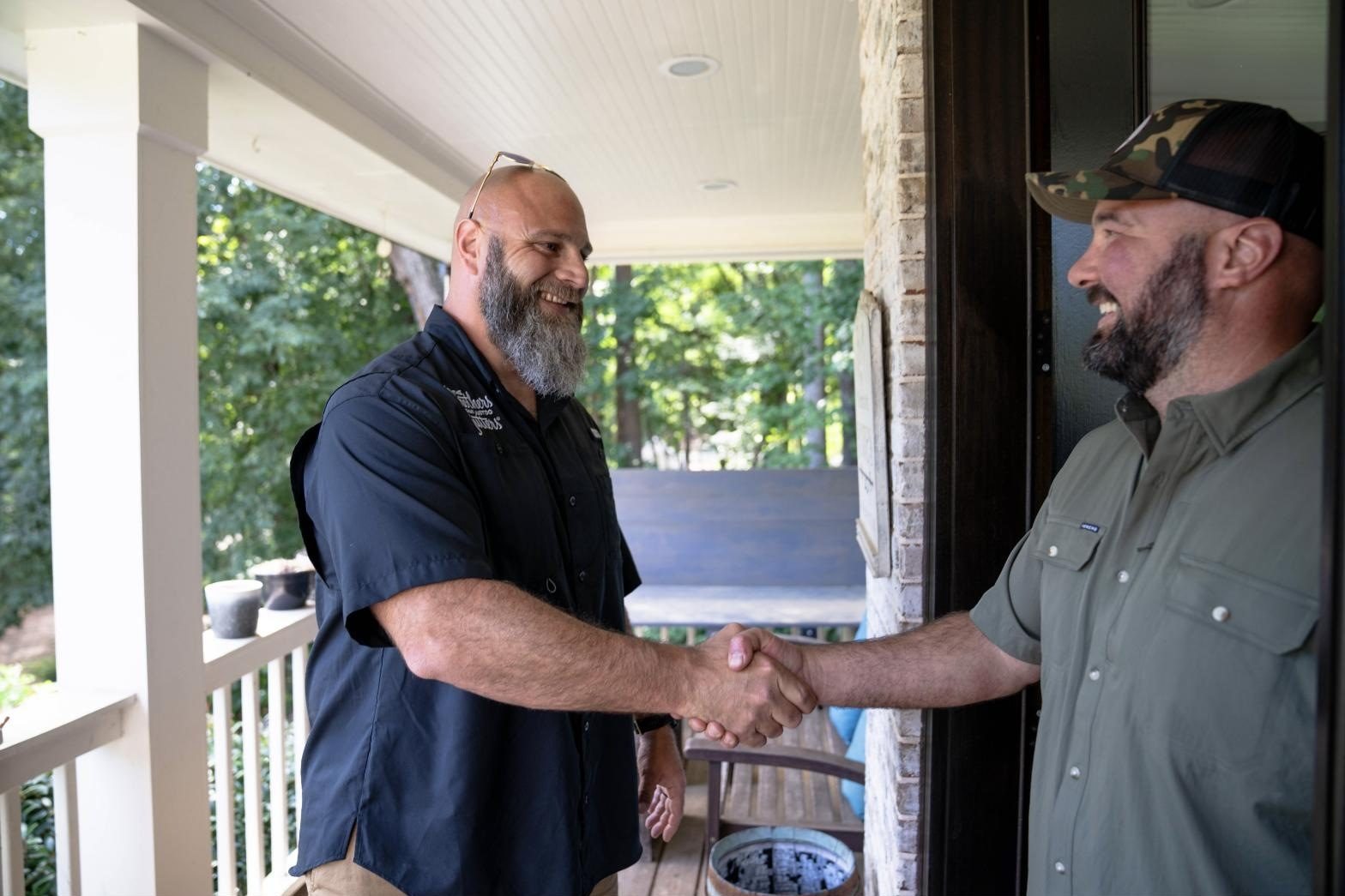 A Solutionist shaking hands with a homeowner on the porch