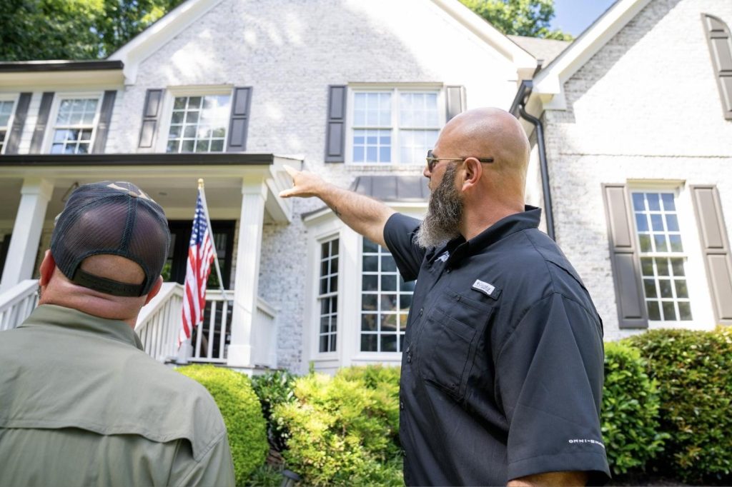 Solutionist walking the roofline with a homeowner