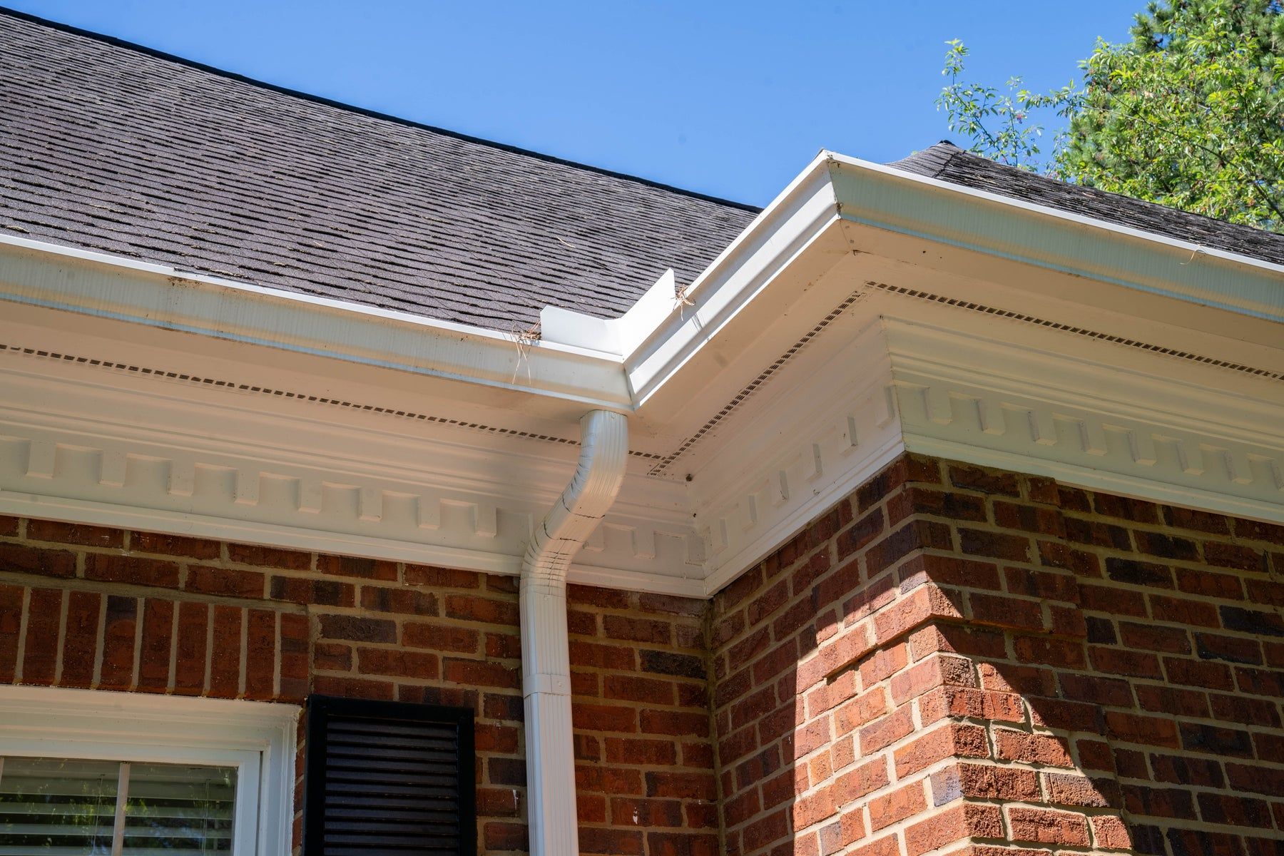 White gutter corner on a brick commercial building